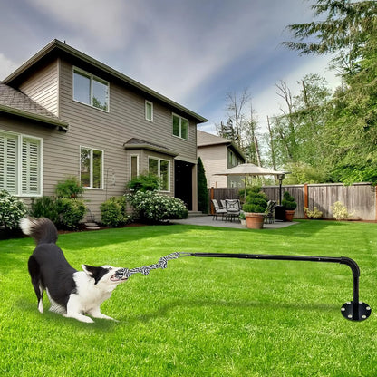 Interactive Tether Tug Dog Toy installed in backyard with black and white dog playing outdoors